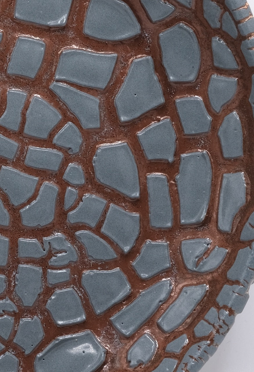 Detail picture of fired bowl with grey crawl glaze on dark clay. Crawling texture when fired to cone 5 or 6.