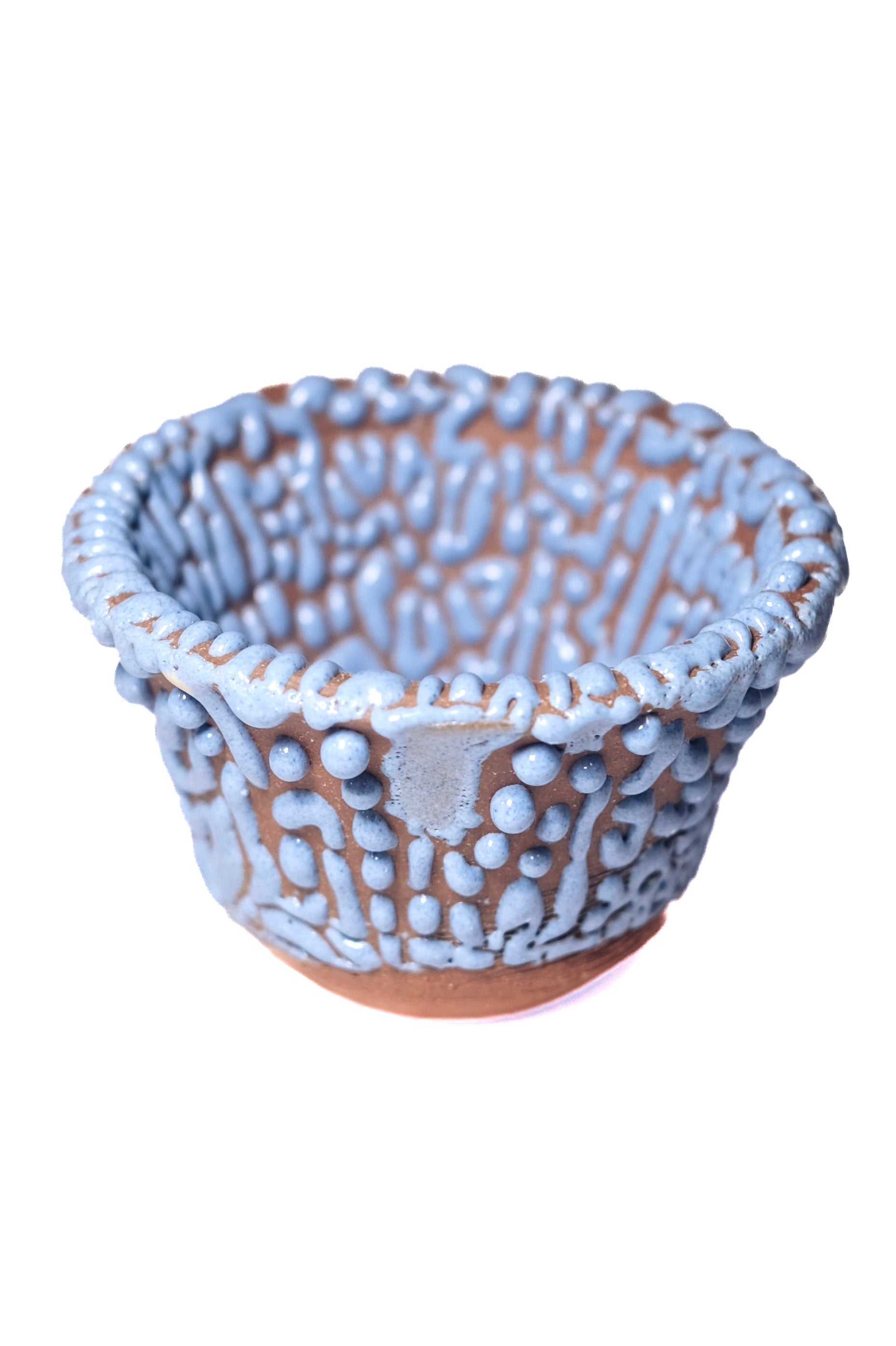 Fired bowl with blue bead glaze on dark clay. Gloop-like texture when fired to cone 5 or 6.
